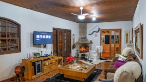a living room with a couch and a fireplace at Fazenda Montanhes in Visconde De Maua