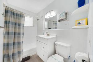 a white bathroom with a sink and a toilet at Beach Apart By Pmi Unit 1 in West Palm Beach +30 photos