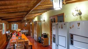 a kitchen and dining room with a table and a refrigerator at Fazenda Montanhes in Visconde De Maua