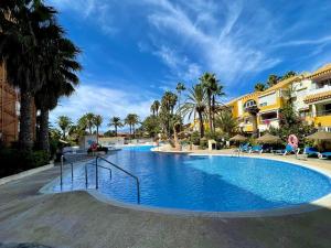 ein großer Swimmingpool in einem Resort mit Palmen in der Unterkunft Golf & Beachside Getaway in Roquetas de Mar