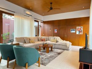 a living room with a couch and a tv at New Spacious 4 bedrooms Family Villa with Skyline View in Panjadakan