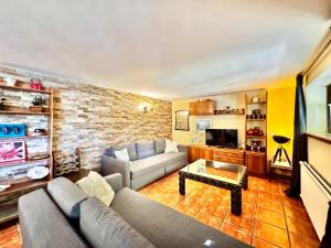 a living room with a couch and a brick wall at Farmhouse Apartment with Pool in Galapagar