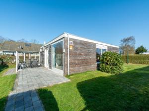 a modular house with a patio in a yard at Bungalow in Julianadorp near Sandy Beach in De Zandloper +12 photos