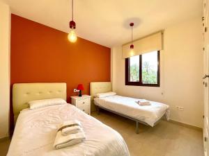 a bedroom with two beds and a window at Sunlit Villa near Golf in Motril +32 photos