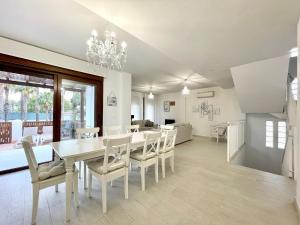 a dining room with a white table and chairs at Sunlit Villa near Golf in Motril