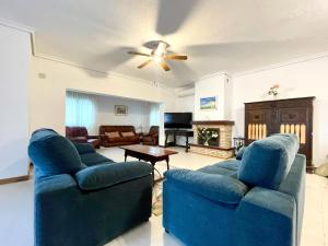 ein Wohnzimmer mit 2 blauen Sofas und einem Deckenventilator in der Unterkunft Villa in Roquetas near Beach & Pool in Roquetas de Mar