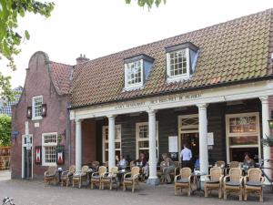 eine Gruppe von Menschen, die vor einem Gebäude sitzen in der Unterkunft Pet-Friendly Bungalow in Warmenhuizen