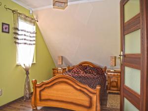 a bedroom with a wooden bed and a window at Holiday Home by Lake in Nowa Wioska in Lubrza