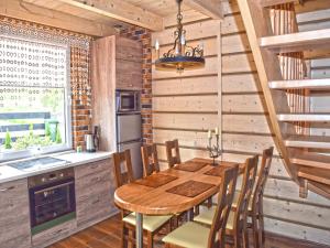 a dining room with a wooden table and chairs at Holiday Home by Lake in Nowa Wioska in Lubrza
