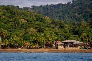 a group of houses on a beach next to a mountain at Casa Prana Nuquí in Nuquí