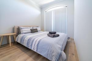a bedroom with a bed and a table at Swan Valley Fantastic Family Home - Aveley in Henley Brook