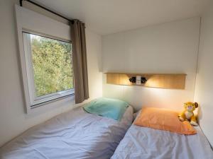 a teddy bear sitting on a bed in a bedroom at Mobil Home 6 Pers avec Terrasse et Cuisine Équipée - API-1-52-561 in Granges-Aumontzey +25 photos