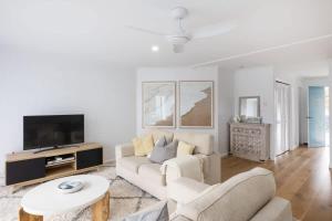 a living room with a couch and a tv at Boo's Nest at Breakers in Mollymook