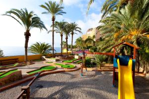 un parque infantil en la playa con palmeras en Diver Aguadulce, en Aguadulce