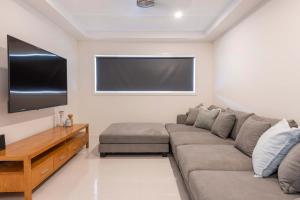 un salon avec un canapé et une télévision à écran plat dans l'établissement Stillwater Stay - Oceanstays - Jetty, à Yamba