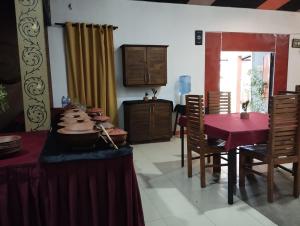 a dining room with a table with a red table cloth at Haritha Holidays in Minneriya