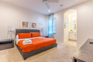 une chambre avec un lit avec des oreillers orange dans l'établissement Elsa's Enchanting Escape just 15 minutes to Disney, à Kissimmee 44 autres photos