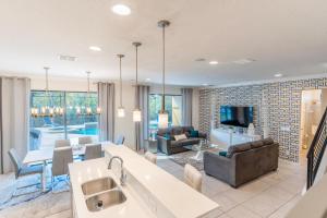 une cuisine et un salon avec un canapé et une table dans l'établissement Elsa's Enchanting Escape just 15 minutes to Disney, à Kissimmee