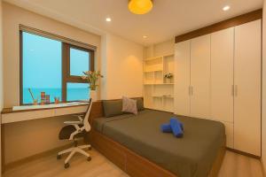 a bedroom with a bed and a desk and a window at Da Nang Daisy Apartment in Danang