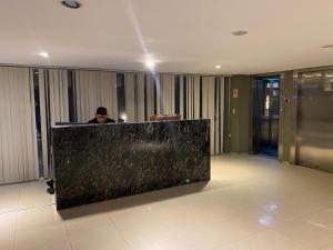 a man sitting at a counter in a lobby at Moderno departamento céntrico, con piscina-Barrio Norte in San Miguel de Tucumán +12 photos