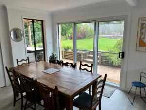 a dining room with a wooden table and chairs at Souira Beach House in Manyana