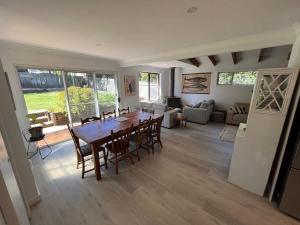 a dining room and living room with a table and chairs at Souira Beach House in Manyana