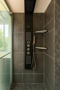 a bathroom with a walk in shower with a phone at Charmant appartement avec jardin, barbecue et Netflix in Méry-sur-Oise