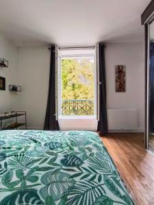 a bedroom with a bed and a large window at Charmant appartement avec jardin, barbecue et Netflix in Méry-sur-Oise