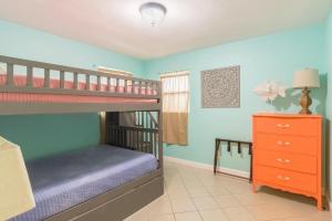 a bedroom with two bunk beds and a dresser at Cowboy Pool Mini Golf Beach Ocean Center in Seabreeze