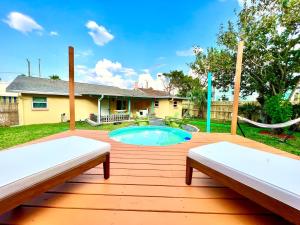 a backyard with a pool and two benches at Cowboy Pool Mini Golf Beach Ocean Center in Daytona Beach