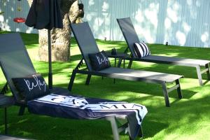 a group of chairs sitting on the grass at CasaMia Only 10 min to Wynwood with New Pool, Bikes, Parking and Privacy in Miami