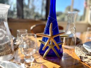 a table with a blue vase with two starfish on it at Rosemary Cottage - short walk to Gannet Beach in Bawley Point