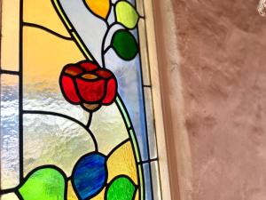 a stained glass window with a flower on it at Rosemary Cottage - short walk to Gannet Beach in Bawley Point +21 photos