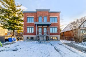 ein Backsteinhaus mit Schnee auf dem Boden in der Unterkunft Longueuil New Stylish 3-BDR free parking close to Dix 30&DT in Longueuil