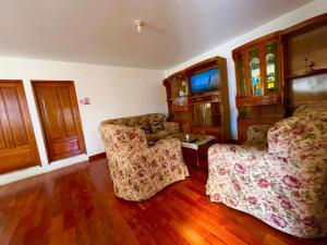 Zimmer mit einem Bett, 2 Stühlen und einem TV in der Unterkunft Casa de campo - Flor del valle in La Paz