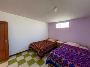 ein Schlafzimmer mit zwei Betten und einem Fenster in der Unterkunft Casa de campo - Flor del valle in La Paz