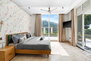 a bedroom with a bed and a large window at SaffronStays Sukh Saklana Haveli Royalty Rooms - Forest-view stay with pool, expansive lawns & dining near Rishikesh and Dehradun Airport in Dehradun