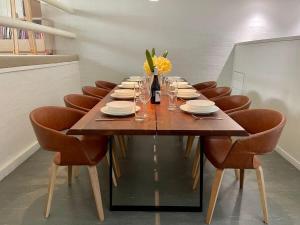 a dining room table with chairs and a bottle of wine at Riversdale Retreat - w. beach & golf course access in Mollymook