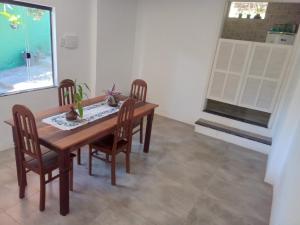 Un comedor con mesa y sillas de madera. en Hospedagen Casa Verde, en Búzios