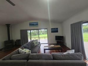 a living room with a couch and a table at Bawley Backyard Haven - family retreat near beach in Bawley Point +17 photos
