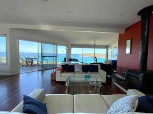 a living room with a couch and a fireplace at Stunning Ocean Views - overlooking Merry Beach in Kioloa