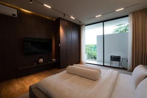 Un dormitorio con una gran cama blanca y una gran ventana. en Villa Blue Sapphire, en Kerobokan 4 fotos más