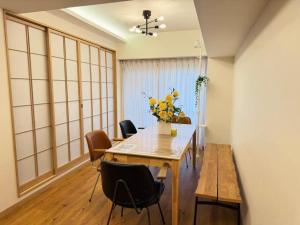 a dining room with a table with flowers on it at World House Kameido -Direct to Akihabara&Shinjuku, near Asakusa &Skytree, 30 mins to Disney by train in Tokyo