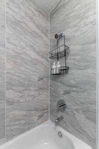 a bathroom with a sink and a shower with marble walls at 3br Hot Tub Retreat Steps From Bayshore Path! in Tampa