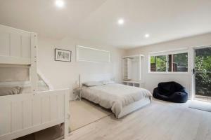 a white bedroom with a bed and a large window at Yaringa at Bawley in Bawley Point +11 photos