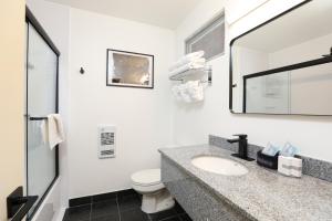 a bathroom with a sink and a toilet and a mirror at Bayshore Inn & Spa in Waterton Park +39 photos