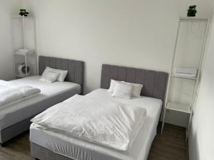 a bedroom with two beds with white sheets at 2-4 People in Peaceful Room Kassel city in Kassel