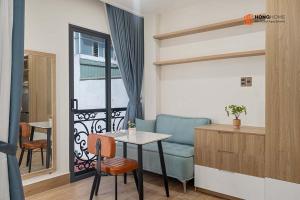 a living room with a table and a blue couch at HongHome Nguyễn Cửu Vân in Ho Chi Minh City