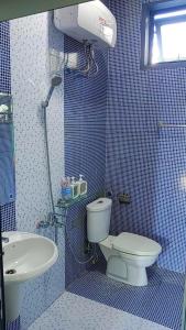 a blue tiled bathroom with a toilet and a sink at Suoi Da Villa 