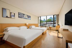 Ένα ή περισσότερα κρεβάτια σε δωμάτιο στο 柏纳酒店阳朔西街店